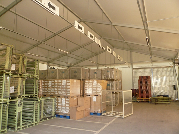 Aluminum clear span storage structure utilized as a logistics warehouse with high vertical clearance for inventory stacking.