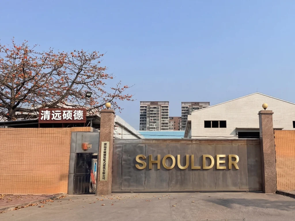 Main entrance gate of Shoulder Tent manufacturing facility featuring a gold company logo.