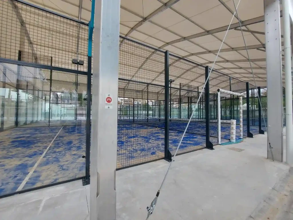 Close-up of heavy-duty aluminum pillars and tension cables supporting a multi-court padel tent.