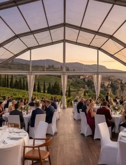 Luxury night wedding reception inside a clear roof aluminum tent with chandeliers.