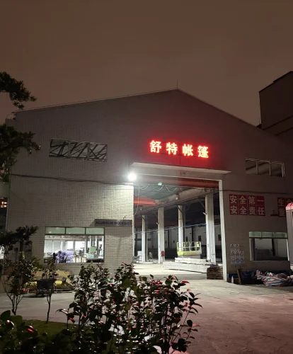 Night view of the Shoulder Tent aluminum workshop facility showing manufacturing capacity.