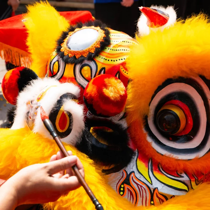 Painting the eye of a traditional Chinese lion during the factory relocation ceremony.