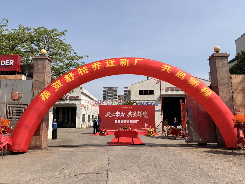 Red inflatable welcome arch at the main entrance of the newly expanded Shoulder Tent factory.