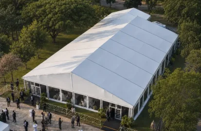 Elevated view of a white aluminum clear span tent with clear sidewalls hosting an outdoor event.
