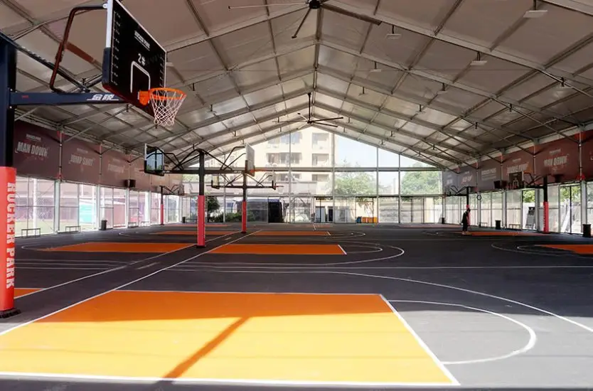 Large clear span sports structure housing multiple indoor basketball courts and hoops.