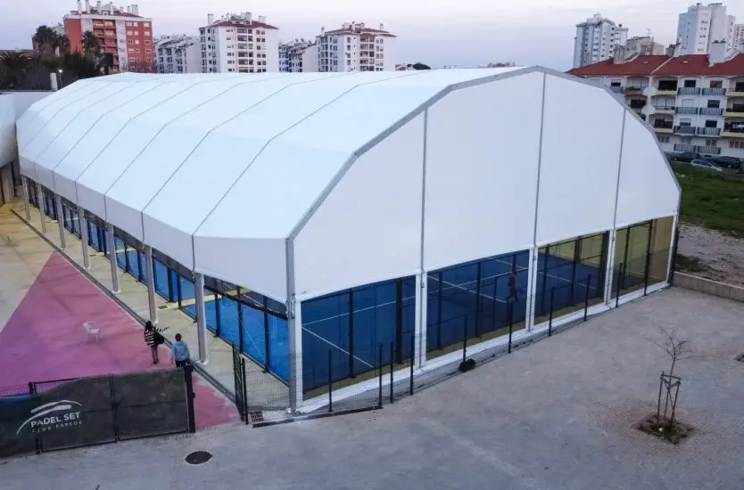 Large white arcum roof clear span structure covering indoor padel courts.