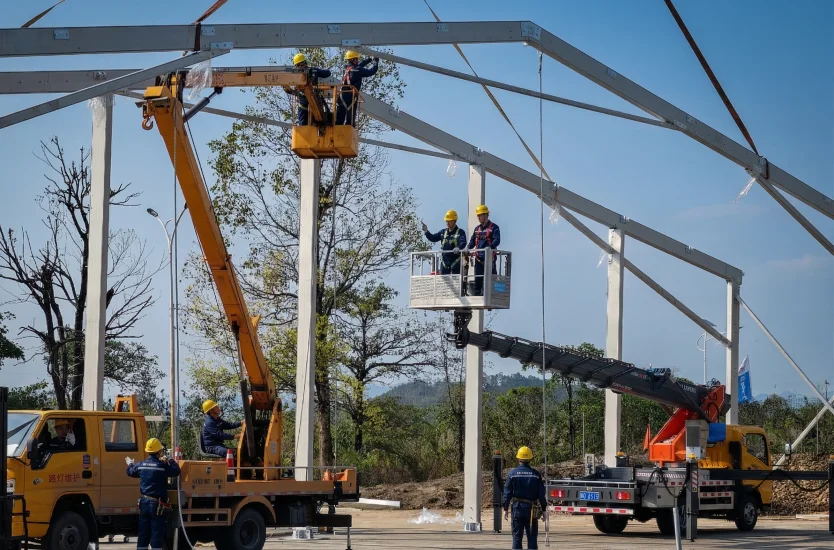 Professional team using cranes to install the heavy duty aluminum frame of a modular clear span tent structure.