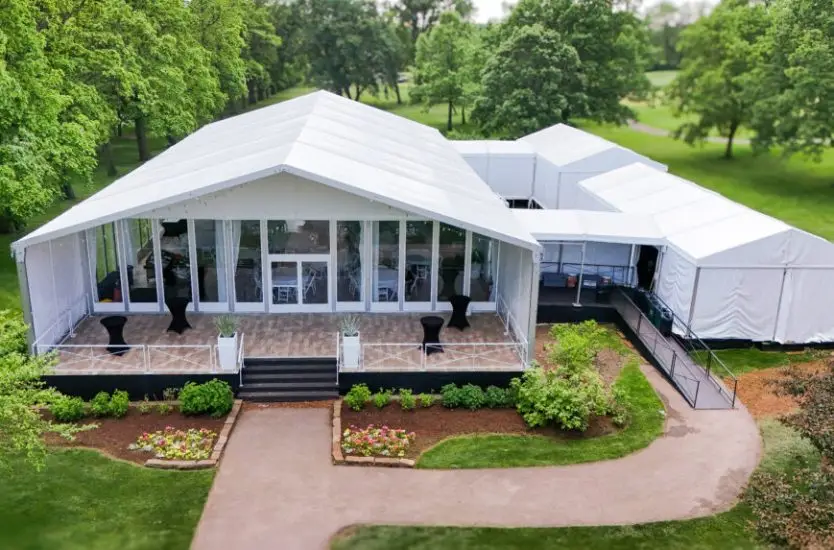 Modular white clear span event tent featuring glass walls and an elevated deck.