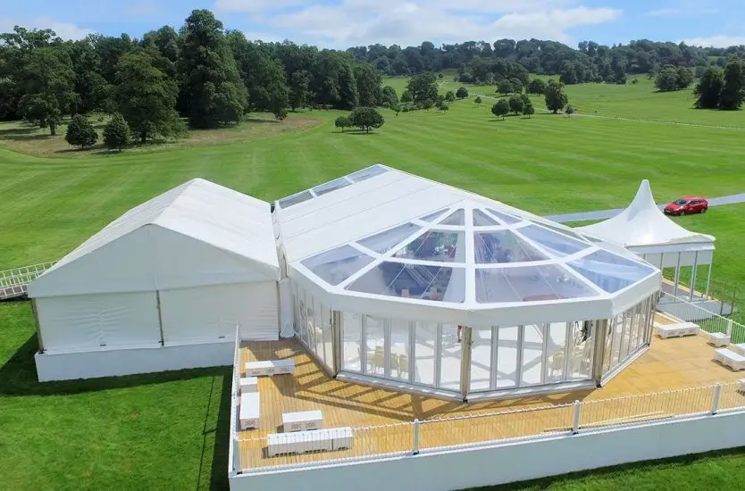 Dual large white arcum aluminum storage tents on a concrete logistics yard.