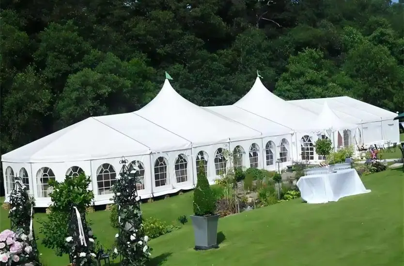 Interior of a massive clear span aluminum dining hall set for a gala banquet.