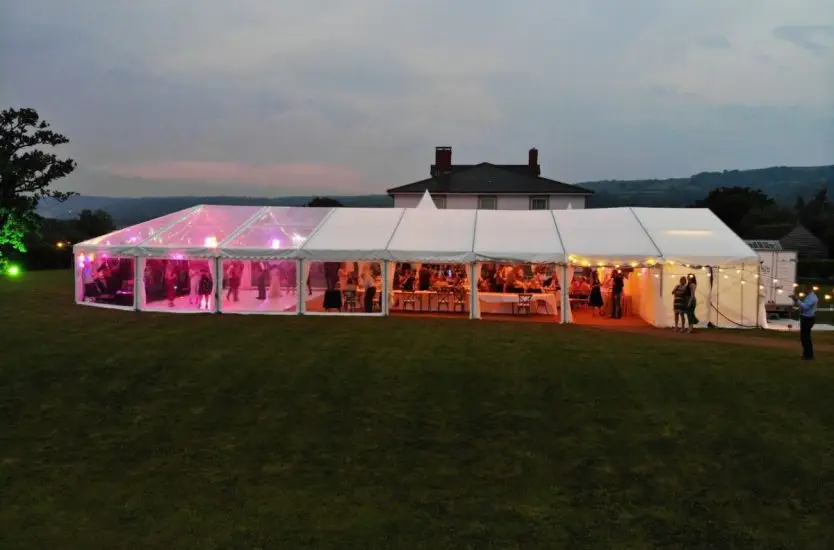 View inside an aluminum clear span A-frame tent with children on indoor blue courts.