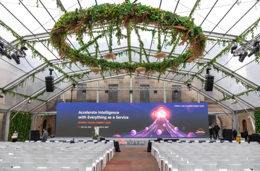 Clear span interior of a transparent roof conference tent with stage and seating.