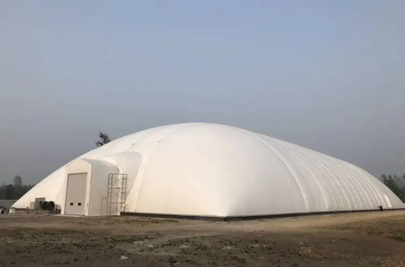 White industrial air dome featuring a prominent structural airlock entrance building.