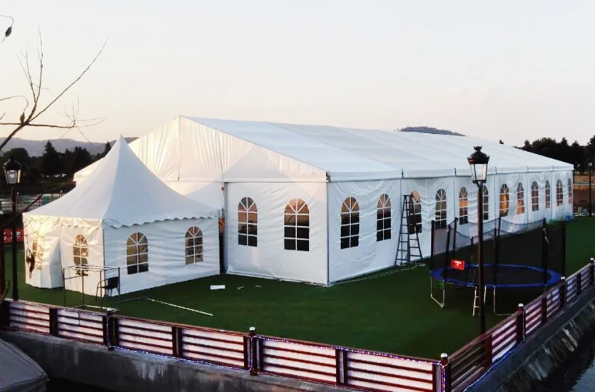 Large white commercial event tent with arched PVC windows and a high peak entrance.